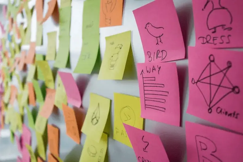 Kreative Brainstorming-Materialien und Post-its an einer Wand